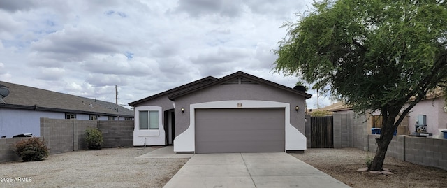 ranch-style house with a garage, concrete driveway, fence, and stucco siding