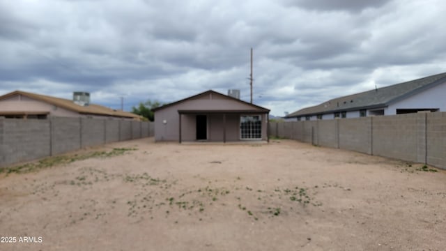 rear view of house with a fenced backyard