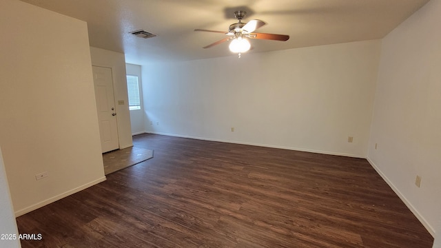 spare room featuring ceiling fan, dark wood finished floors, and baseboards