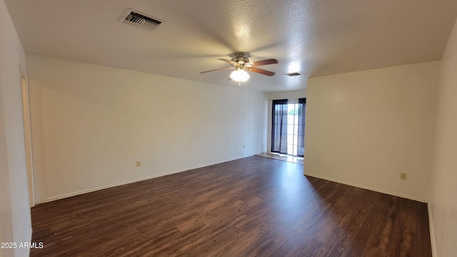 empty room featuring ceiling fan, dark wood finished floors, baseboards, and a textured ceiling