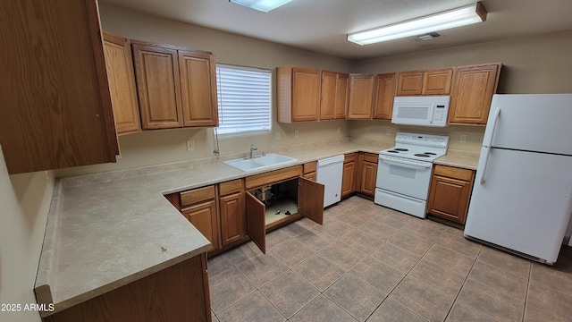 kitchen featuring white appliances, a sink, light countertops, and light tile patterned floors