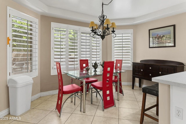 dining area featuring baseboards, an inviting chandelier, and light tile patterned floors