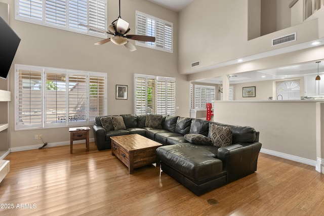 living area with visible vents, a ceiling fan, and light wood-type flooring