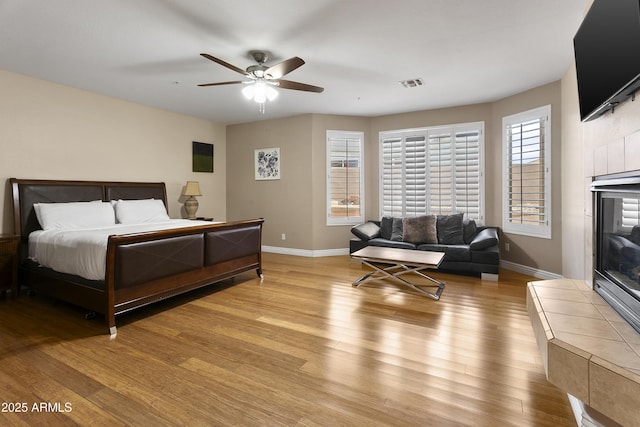 bedroom featuring visible vents, a ceiling fan, baseboards, and light wood-style floors