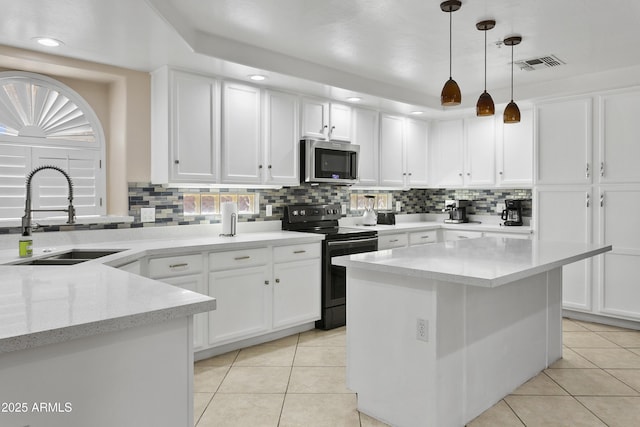 kitchen with a sink, stainless steel microwave, electric range, and light tile patterned flooring