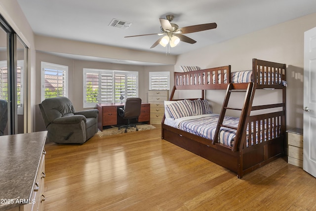 bedroom featuring ceiling fan, light wood finished floors, and visible vents
