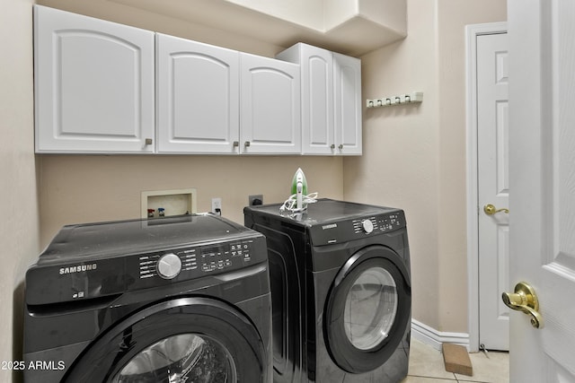 clothes washing area featuring light tile patterned floors, separate washer and dryer, baseboards, and cabinet space
