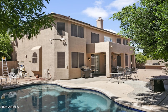 back of property with central AC unit, a patio area, and stucco siding