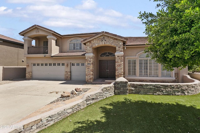 mediterranean / spanish-style house with an attached garage, stucco siding, driveway, and stone siding