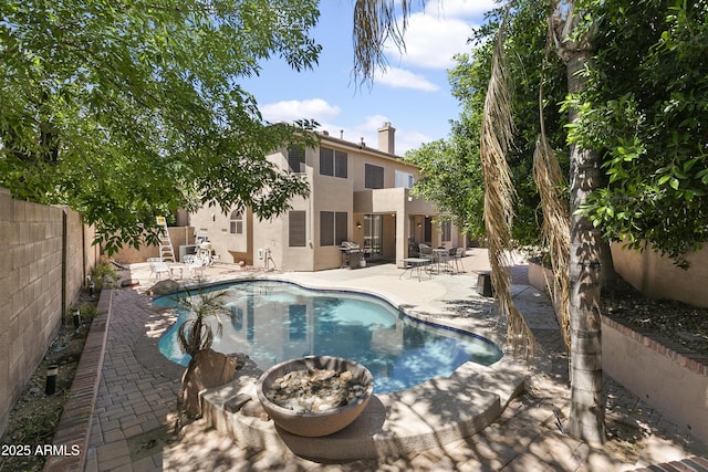 view of pool featuring grilling area, a patio area, a fenced in pool, a fenced backyard, and a fire pit