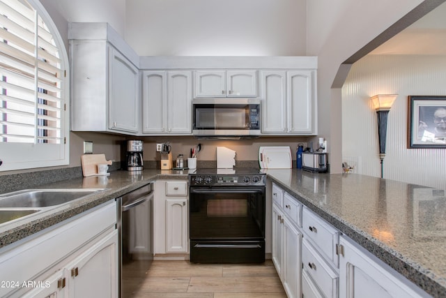 kitchen featuring plenty of natural light, white cabinets, and appliances with stainless steel finishes