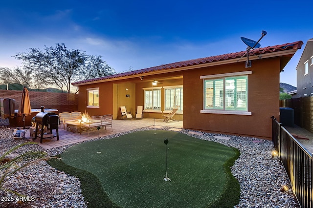 13145 W Whisper Rock Trl, Peoria, AZ 85383 - back of house with a putting area, a fire pit, a patio, a fenced backyard, and a tiled roof