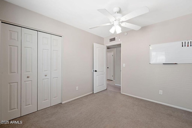 unfurnished bedroom featuring baseboards, carpet, a closet, and visible vents