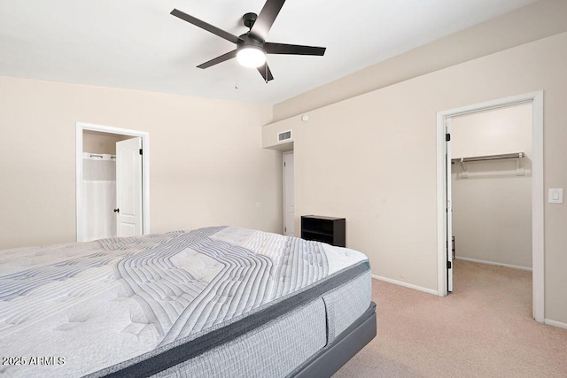 bedroom with visible vents, baseboards, a closet, a spacious closet, and light carpet