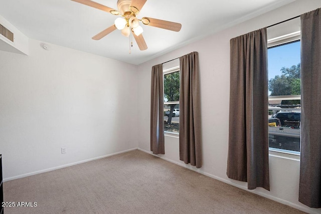 unfurnished room featuring baseboards, ceiling fan, carpet, and visible vents
