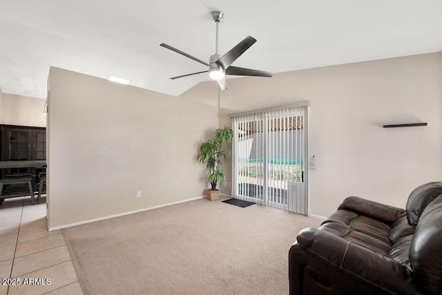 living room with a ceiling fan, vaulted ceiling, light tile patterned floors, baseboards, and light carpet