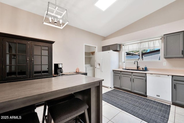 kitchen featuring white appliances, gray cabinetry, and a sink