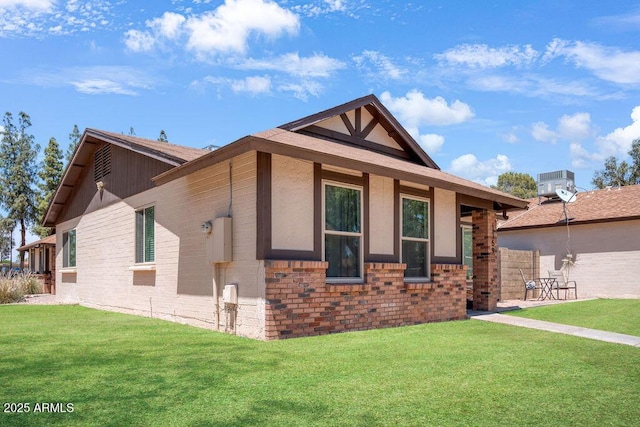 view of front of house with central AC, brick siding, and a front yard
