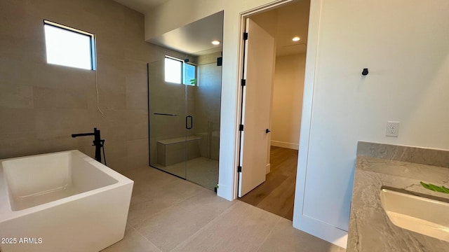 bathroom with independent shower and bath, vanity, and tile patterned floors