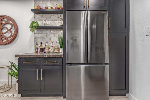 indoor dry bar featuring freestanding refrigerator, baseboards, and wood finished floors