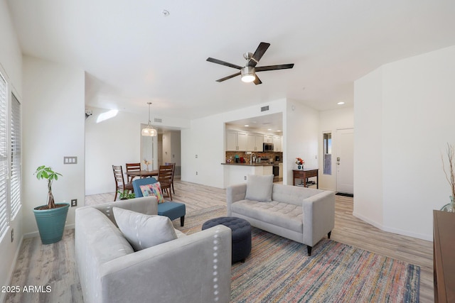 living room featuring ceiling fan and light hardwood / wood-style flooring