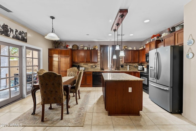 kitchen with decorative light fixtures, sink, a center island, light stone counters, and black appliances