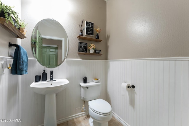 bathroom with toilet and tile patterned flooring