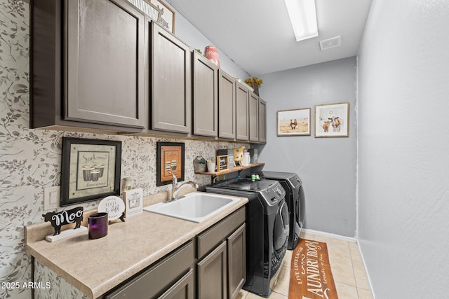 clothes washing area featuring cabinets, washing machine and dryer, sink, and light tile patterned flooring