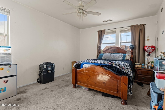 carpeted bedroom with stainless steel fridge and ceiling fan