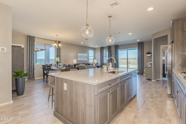 kitchen featuring stainless steel appliances, a center island with sink, plenty of natural light, and sink