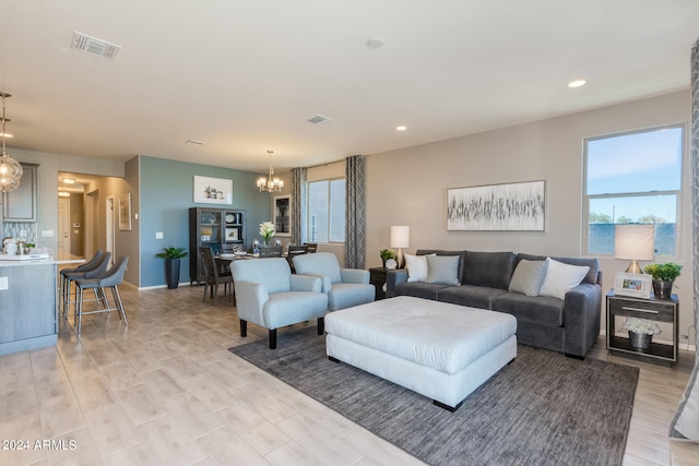 living room featuring light wood-type flooring and an inviting chandelier