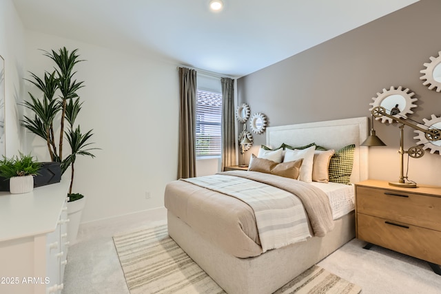 bedroom with light colored carpet and baseboards