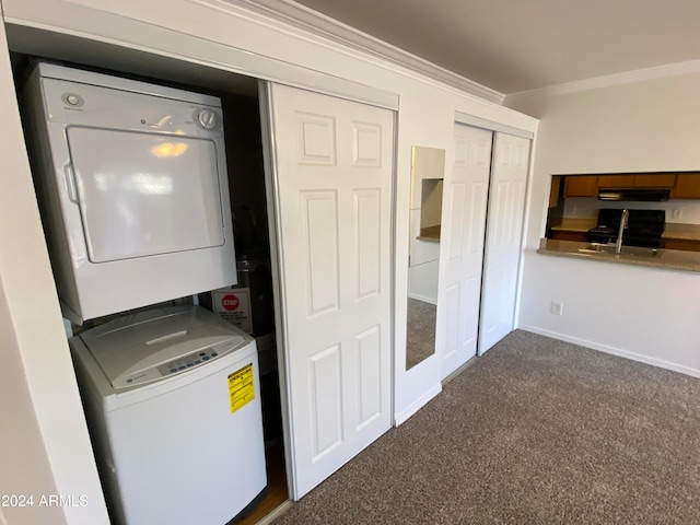 laundry area featuring dark carpet, stacked washer / dryer, ornamental molding, and sink