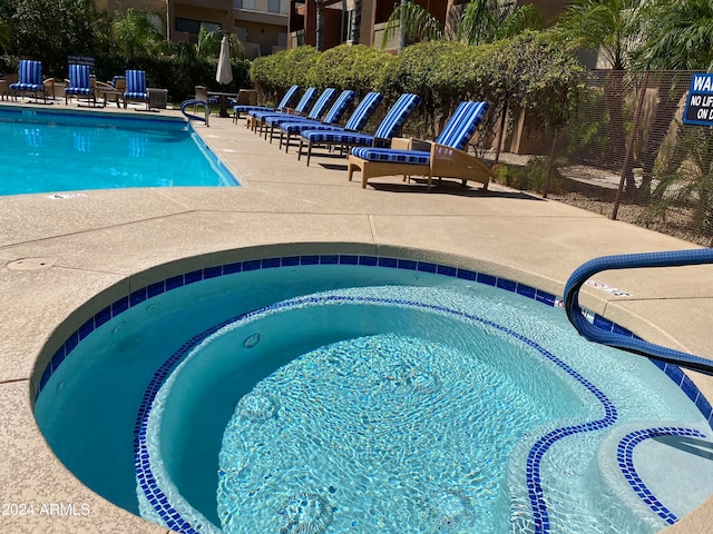 view of swimming pool featuring a community hot tub and a patio