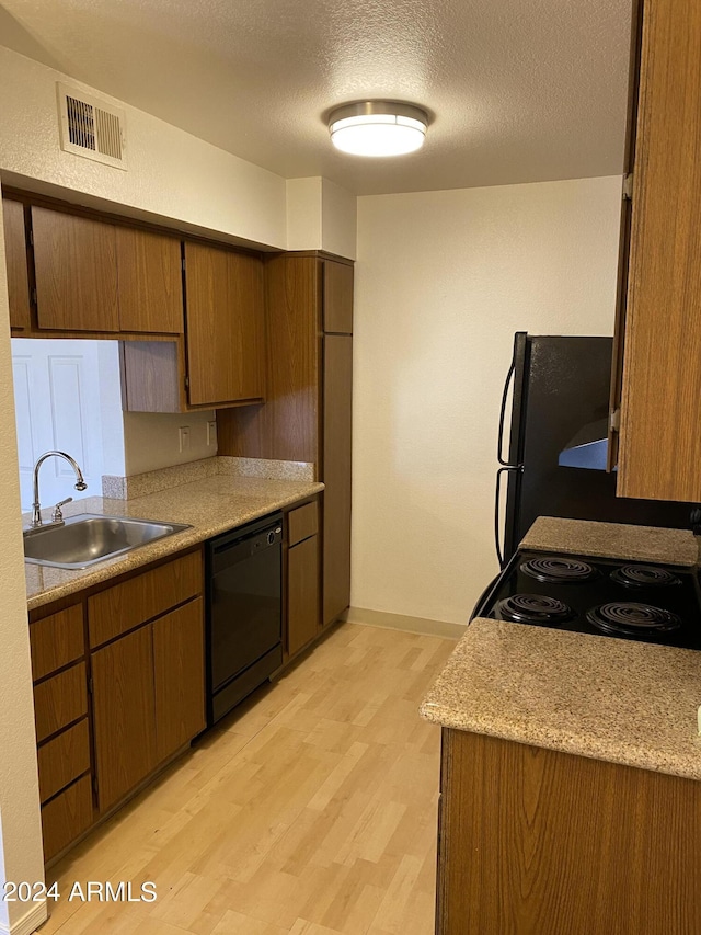 3500 N Hayden Rd Unit 1903, Scottsdale, AZ 85251 - kitchen with black appliances, a sink, light wood-style floors, light countertops, and a textured ceiling