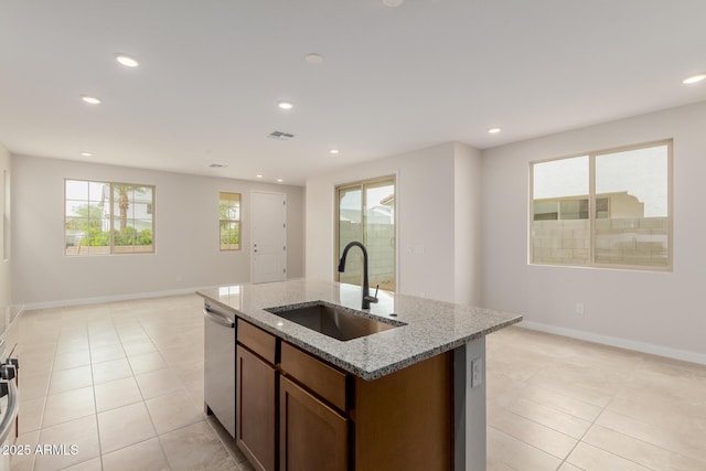 kitchen with dishwasher, open floor plan, light stone countertops, a sink, and recessed lighting