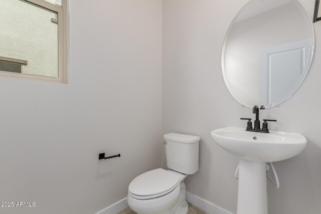 bathroom with toilet and baseboards