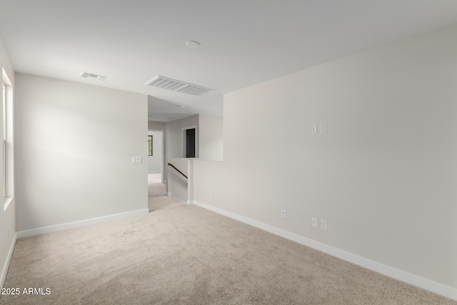 carpeted empty room with visible vents and baseboards