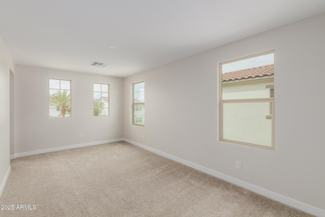 carpeted empty room with visible vents and baseboards