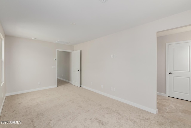 empty room with light colored carpet and baseboards