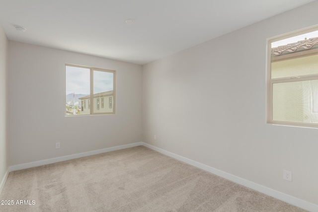 carpeted empty room with baseboards