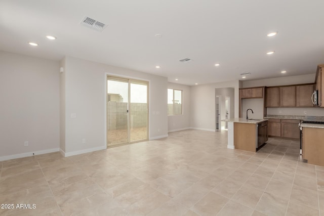 kitchen with a kitchen island with sink, a sink, visible vents, open floor plan, and dishwasher