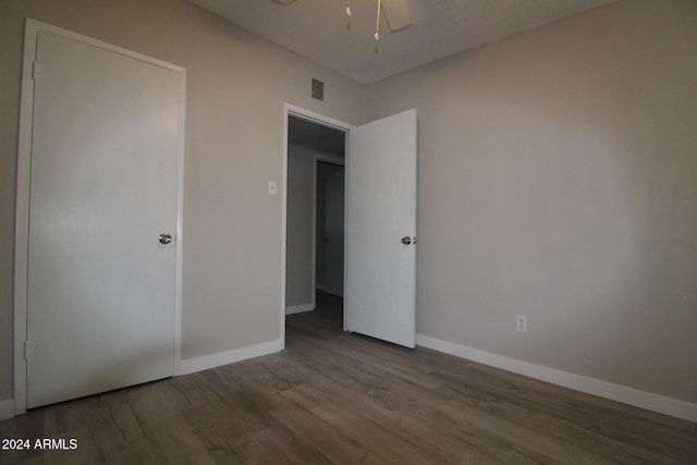 5918 S Grover Cyn Rd, Claypool, AZ 85532 - unfurnished bedroom featuring wood finished floors, baseboards, and ceiling fan