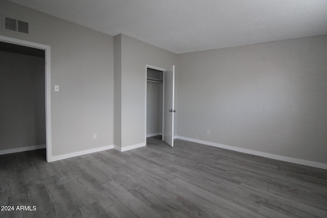 5918 S Grover Cyn Rd, Claypool, AZ 85532 - unfurnished bedroom featuring wood finished floors, baseboards, and a closet
