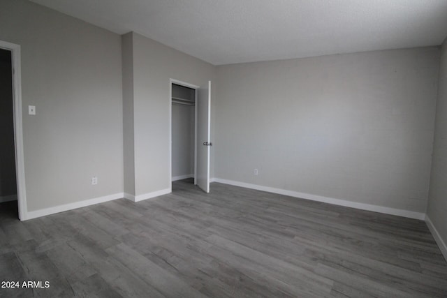 5918 S Grover Cyn Rd, Claypool, AZ 85532 - unfurnished bedroom with wood finished floors, baseboards, and a closet