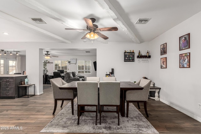 dining room with visible vents, beamed ceiling, baseboards, and wood finished floors