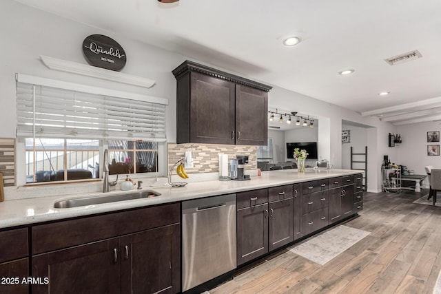 kitchen with a sink, visible vents, dark brown cabinets, backsplash, and dishwasher