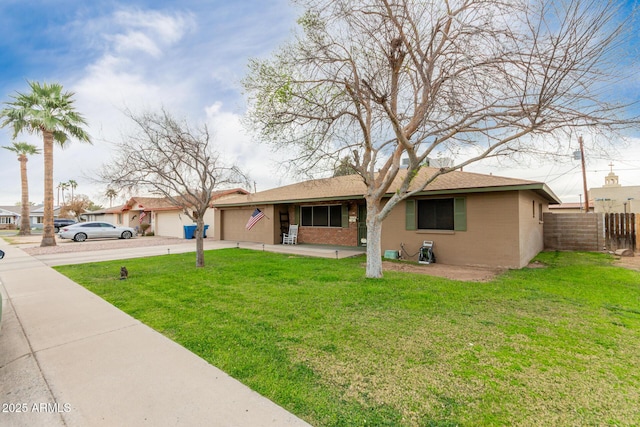 single story home with brick siding, an attached garage, a front yard, fence, and driveway