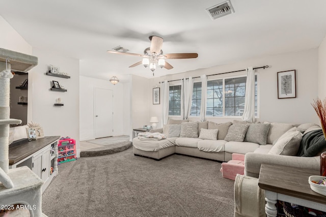 living room featuring carpet floors, visible vents, and a ceiling fan