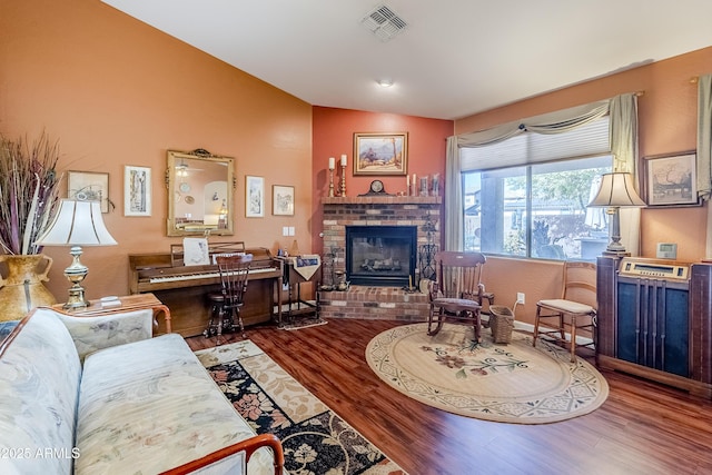 living room featuring lofted ceiling, wood-type flooring, and a fireplace